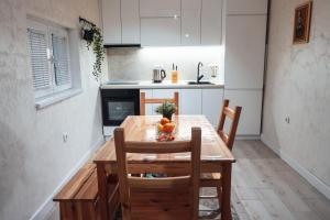 Il comprend une petite cuisine avec une table et des chaises en bois. dans l'établissement Boom House Fruska Gora, à Irig