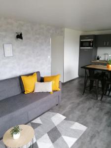 ein Wohnzimmer mit einem Sofa und einem Tisch in der Unterkunft La Maison Bleue in Saint-Étienne-lès-Remiremont