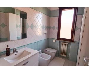 a bathroom with a sink and a toilet and a window at Olga & Giò - Vicino al Centro di Cesena in Cesena