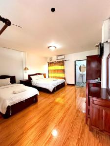 a bedroom with two beds and a wooden floor at Vang Vieng Global Hostel in Vang Vieng