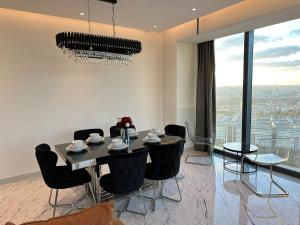 ein Esszimmer mit einem Tisch und Stühlen sowie einem großen Fenster in der Unterkunft most luxury 2+1 apt at sinpas queen bomonti f 40-90 in Istanbul