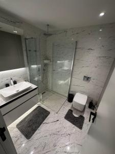 ein Bad mit einer Dusche, einem Waschbecken und einem WC in der Unterkunft most luxury 2+1 apt at sinpas queen bomonti f 40-90 in Istanbul