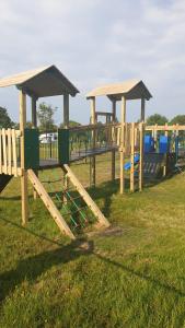 a row of wooden play structures in a park at Holiday Lodge, sleeps 4, with sea & countryside views in Ore