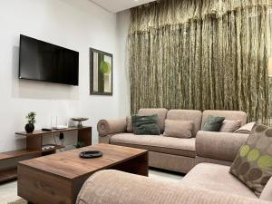 a living room with two couches and a flat screen tv at Sublime duplex au Bardo Tunis in Le Bardo