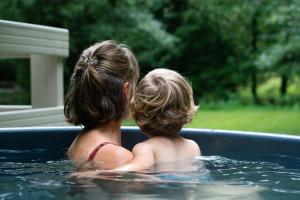 a couple of children sitting in a hot tub at Charme à Graide in Graide