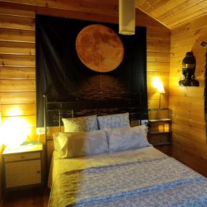 a bedroom with a bed with a wooden wall at Casa La Colina Mandarina II Casa de madera in Tahal
