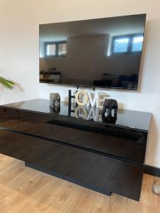 uma sala de estar com uma mesa preta e um espelho em Appartement - La Meute em Magland