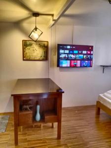 Z and j Transient Pad في بوتوان: غرفة معيشة مع طاولة وتلفزيون على الحائط