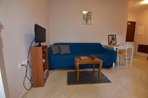 - un salon avec un canapé bleu et une table dans l'établissement Magenta, à Igoumenítsa