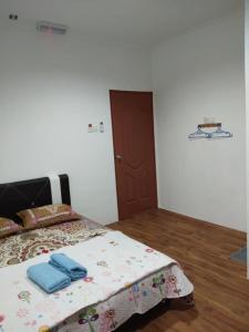 um quarto com uma cama com toalhas azuis em Alin Roomstay Dungun em Dungun