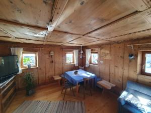 a dining room with a blue table in a wooden room at Apartement Schuster Lake Prags Braies in Braies