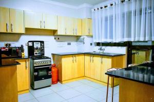 een keuken met houten kasten en een fornuis met oven bij Bee Furnished apartments 3 in Nakuru
