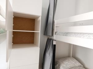 a small bedroom with white bunk beds at Daydream Medano Coliving in El Médano