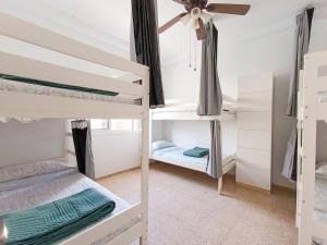 a room with three bunk beds in a hostel at Daydream Medano Coliving in El Médano