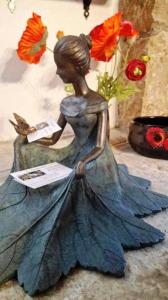 Eine Statue einer Frau in einem Kleid, die ein Buch liest. in der Unterkunft Les GARGOUILLES Gorges du Tarn - Millau in Boyne