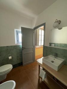een badkamer met een witte wastafel en een toilet bij In Campagna in Santa Fiora