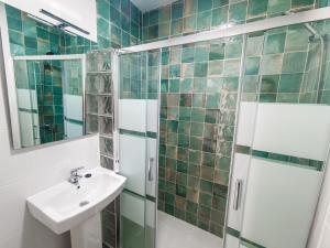 W łazience znajduje się umywalka i prysznic. w obiekcie Daydream Medano Coliving w mieście El Médano