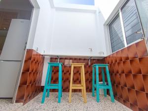 two green and blue stools in front of a wall at Daydream Medano Coliving in El Médano