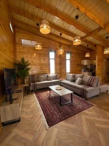 a large living room with couches and a table in it at كوخ آفيري Aviary Hut in Al-ʿUla