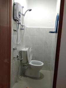 a bathroom with a toilet and a shower in it at Alin Roomstay Dungun in Dungun