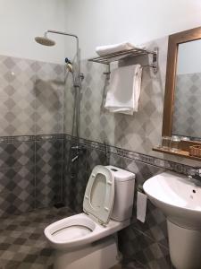 a bathroom with a toilet and a sink at The Highland House in Buon Ma Thuot