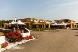 a large building with some flowers in front of it at Hotel Petri Marini in Aglientu