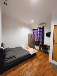 a bedroom with a bed and a desk in a room at Alin Roomstay Dungun in Dungun
