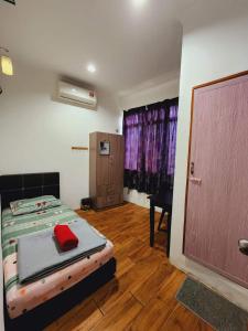 a bedroom with a bed and a desk and a door at Alin Roomstay Dungun in Dungun