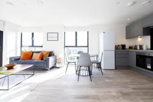 a kitchen and living room with a couch and a table at GuestReady - A modern getaway in Vauxhall in Liverpool