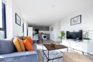 a living room with a blue couch and a table at GuestReady - A modern getaway in Vauxhall in Liverpool