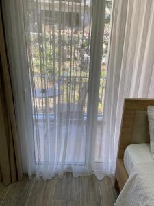 a bedroom with a large window with white curtains at Persephone in Himare