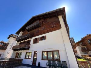 a large white building with wooden accents at Gin Luxury Apartments City Centre in Livigno
