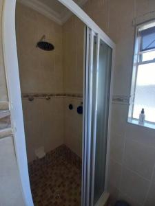 a shower with a glass door in a bathroom at The Miller's Airbnb in Cape Town