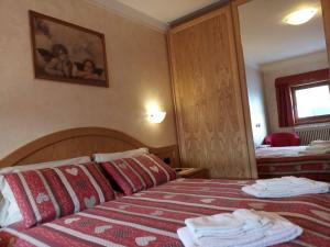 um quarto de hotel com uma cama com toalhas em Chalet Claudia em Livigno