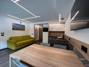 ein Wohnzimmer mit einem grünen Sofa und einem Tisch in der Unterkunft Gin Luxury Apartments City Centre in Livigno