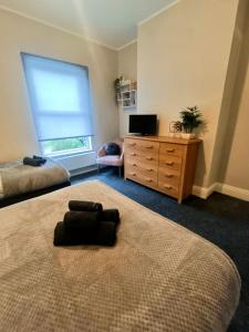 een slaapkamer met een bed, een dressoir en een raam bij Rosa House in Darlington