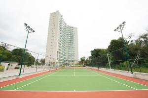 un court de tennis avec un bâtiment en arrière-plan dans l'établissement RIOSTAY FLAT´s (RioCentro, Jeunesse Arena e Rock-in-Rio), à Rio de Janeiro