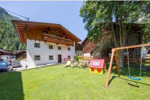 un cortile con parco giochi di fronte a una casa di Farmerhouse by Northsouth Aparthments a Sölden