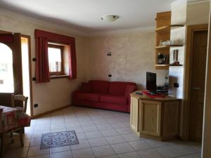 a living room with a red couch and a television at Chalet Claudia in Livigno