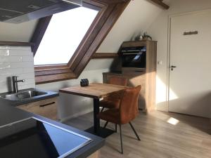 een keuken met een houten tafel en een wastafel bij Ruim appartement met sauna, Zuidstraat 125 in Westkapelle in Westkapelle