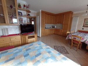 a bedroom with a bed and a table and a kitchen at Chalet Claudia in Livigno