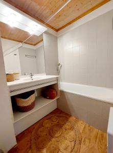 a bathroom with a sink and a bath tub at Le Grand Valmeinier - 6 pers - 2 SDB - 1 terrasse plein sud in Valmeinier