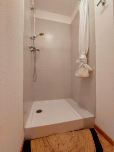 La salle de bains est pourvue d'une douche, de toilettes et d'un tapis. dans l'établissement Le Grand Valmeinier - 6 pers - 2 SDB - 1 terrasse plein sud, à Valmeinier