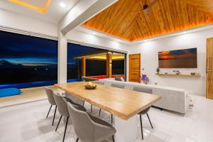 a dining room with a wooden table and chairs at Villa Nirvana - Wonderful Sea View in Koh Samui 