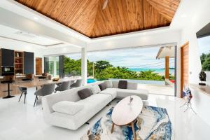 ein Wohnzimmer mit einem Sofa und einem Tisch in der Unterkunft Villa Nirvana - Wonderful Sea View in Koh Samui 