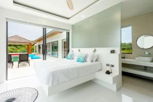 una camera con un grande letto bianco e un bagno di Villa Nirvana - Wonderful Sea View a Ko Samui