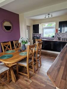 a dining room with a wooden table and a kitchen at Home in Melton Mowbray in Melton Mowbray