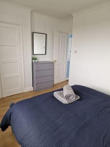 a bedroom with a blue bed with a towel on it at Home in Melton Mowbray in Melton Mowbray