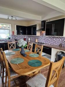 a kitchen with a wooden table with chairs and a kitchen counter at Home in Melton Mowbray in Melton Mowbray