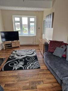 a living room with a couch and a flat screen tv at Home in Melton Mowbray in Melton Mowbray